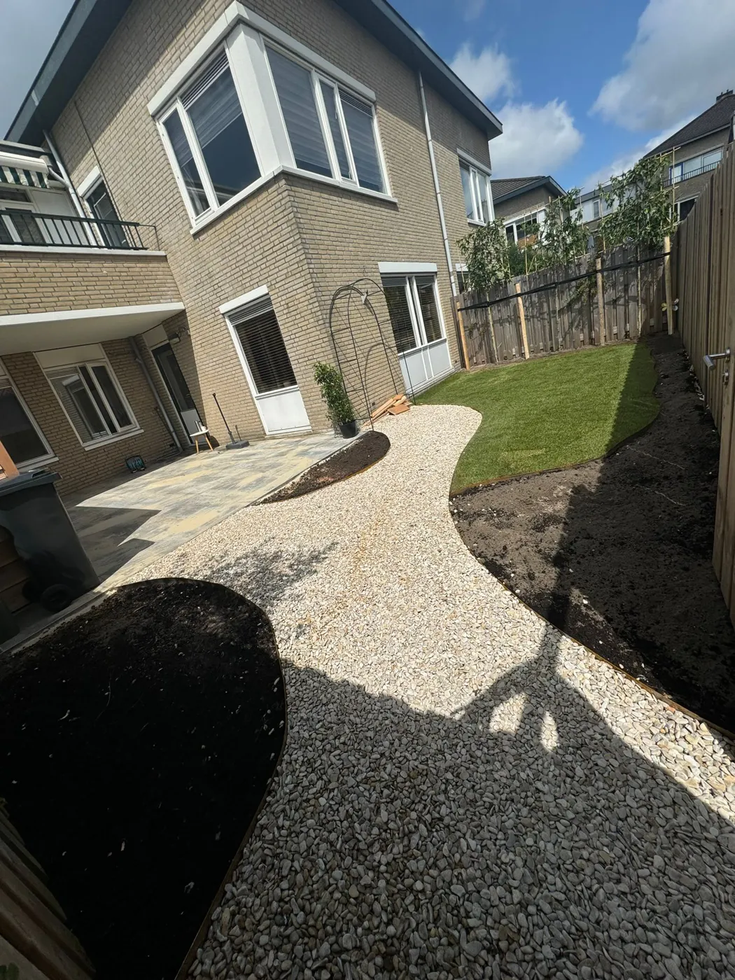 Grindpad in een bocht langs het huis