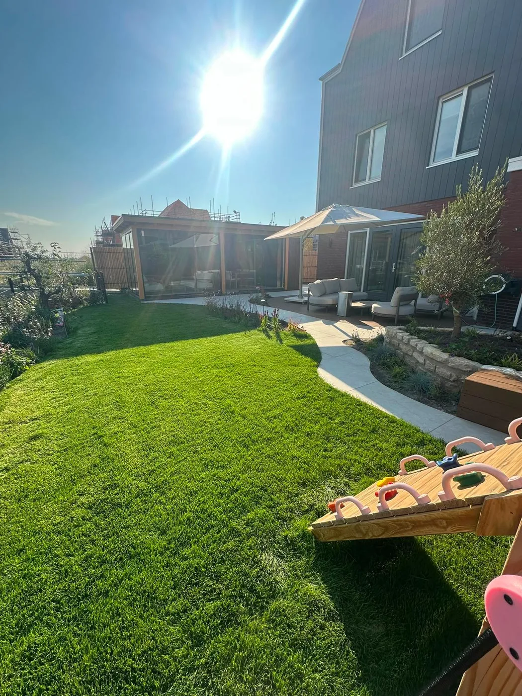 Gazon met de tuinkamer achterin