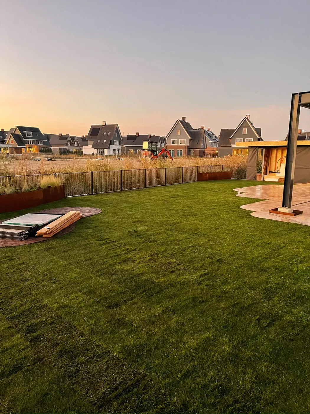 Gazon tot aan het water bij zonsondergang